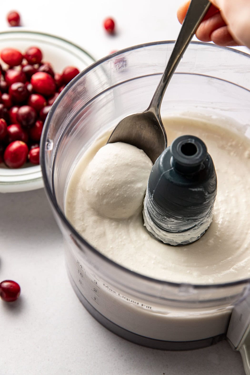 Overhead view of a food processor filled with smooth whipped cottage cheese and cream cheese.
