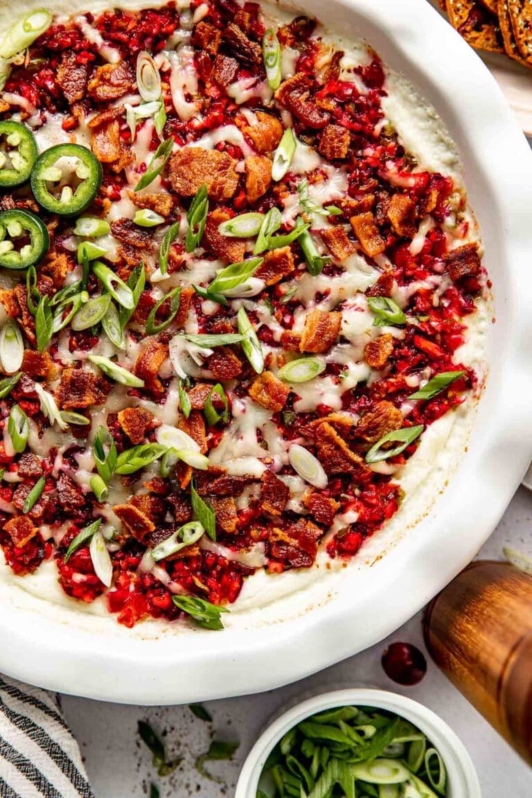 Overhead view of a pie dish filled with cranberry jalapeno dop topped with green onions.