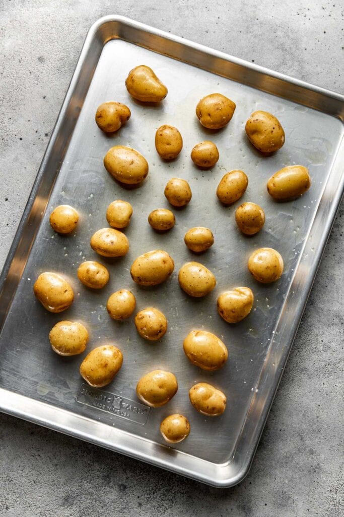 Overhead view of Baby Potatoes on a sheet pan ready for roasting. 