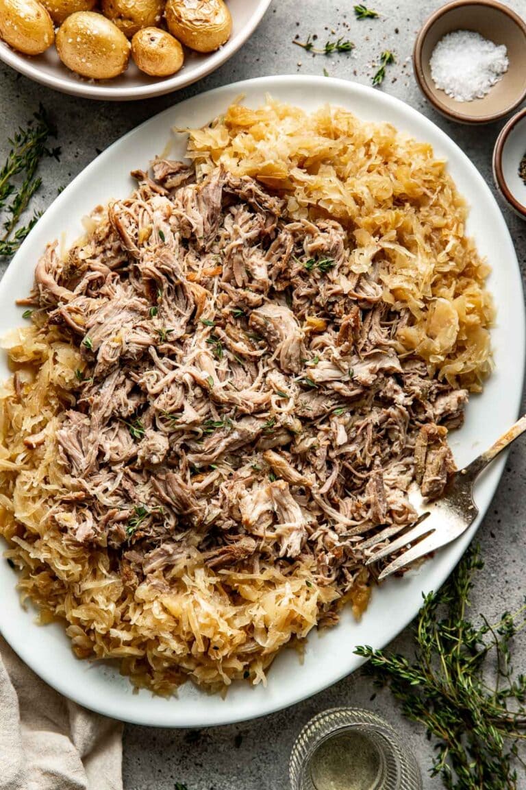 Making pork & sauerkraut in the slow cooker is my new favorite method, since it results in the most tender and delicious shredded pork that gets infused with all those delicious briny flavors of the kraut. 