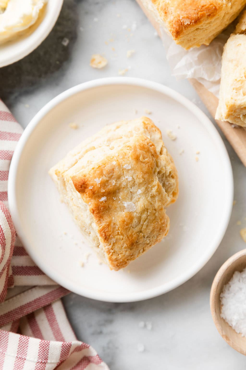 Overhead view of a freshly baked biscuit topped with flakey sea salt. 