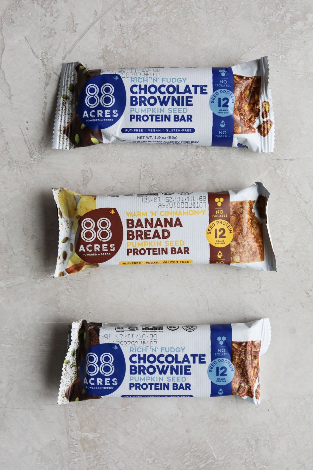 Three 88 Acres Protein Bars on a light grey background.