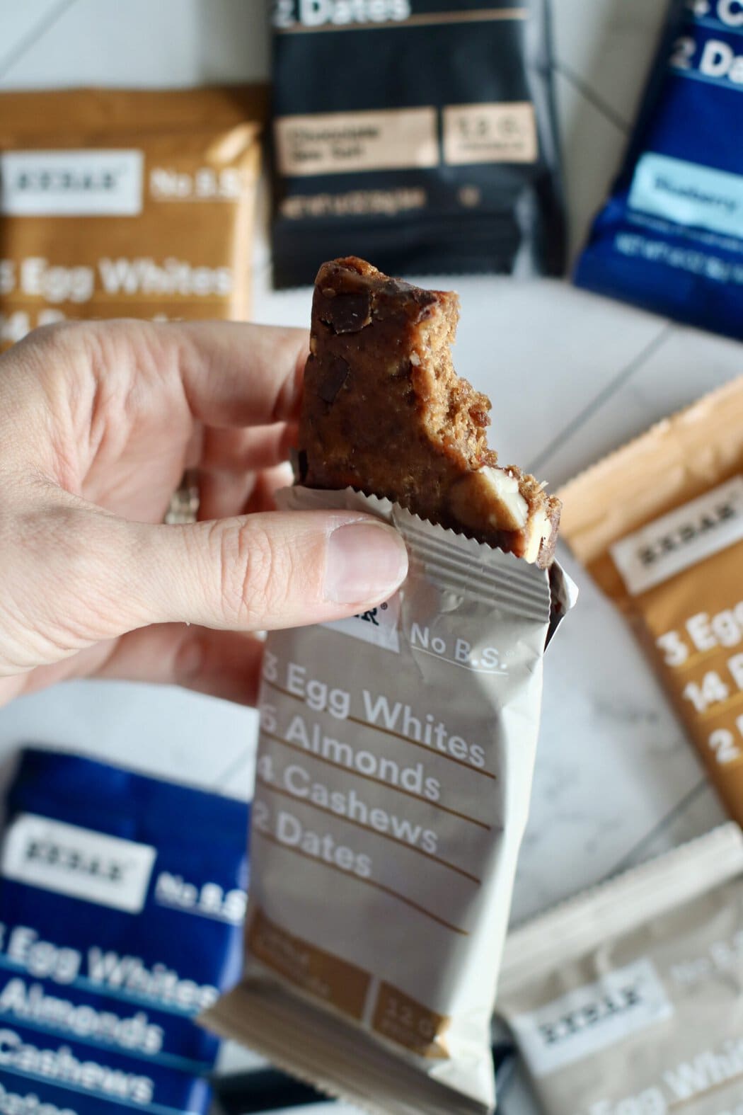Close up view of a hand holding an RX protein bar to show the inside texture.