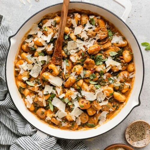 Overhead view of Sausage And Gnocchi Skillet topped with fresh basil and shaved parmesan