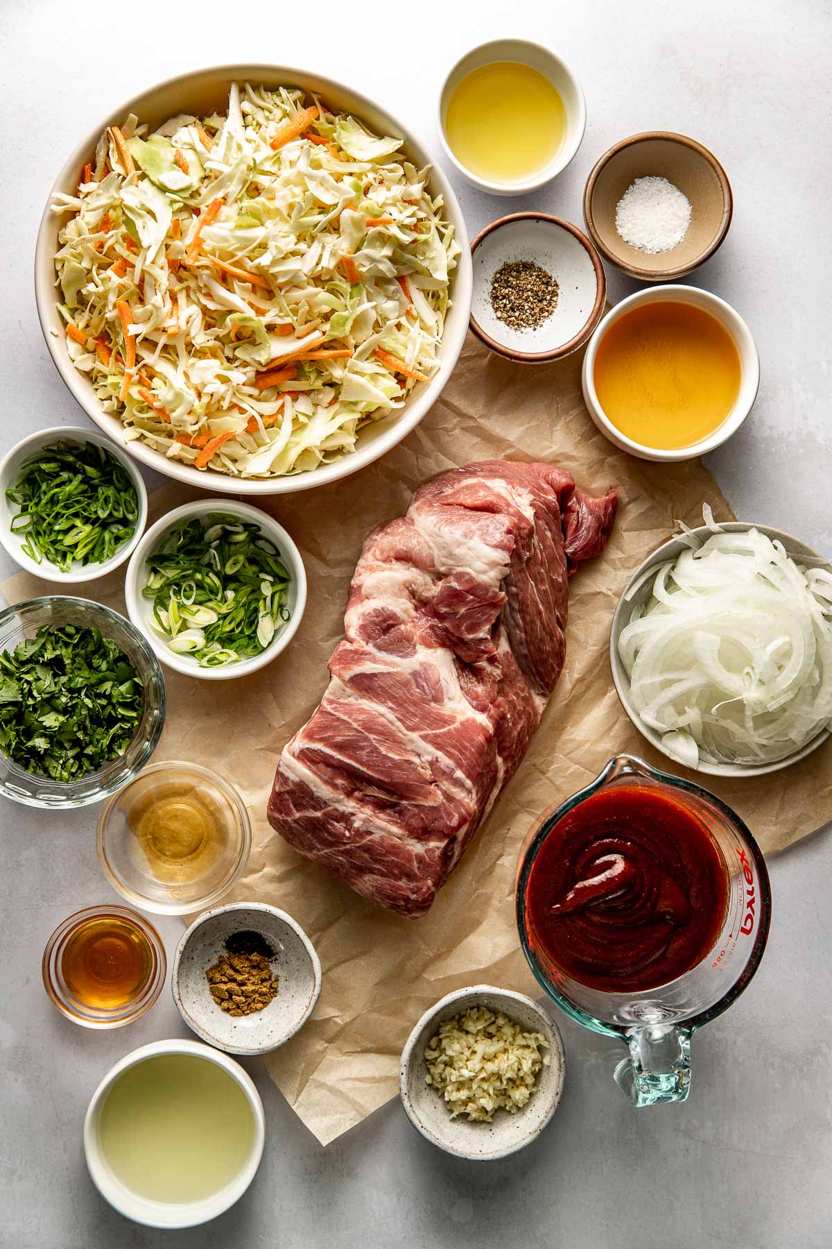 Overhead view of a variety of ingredients for Crockpot Pulled Pork Bowls in different sized bowls.