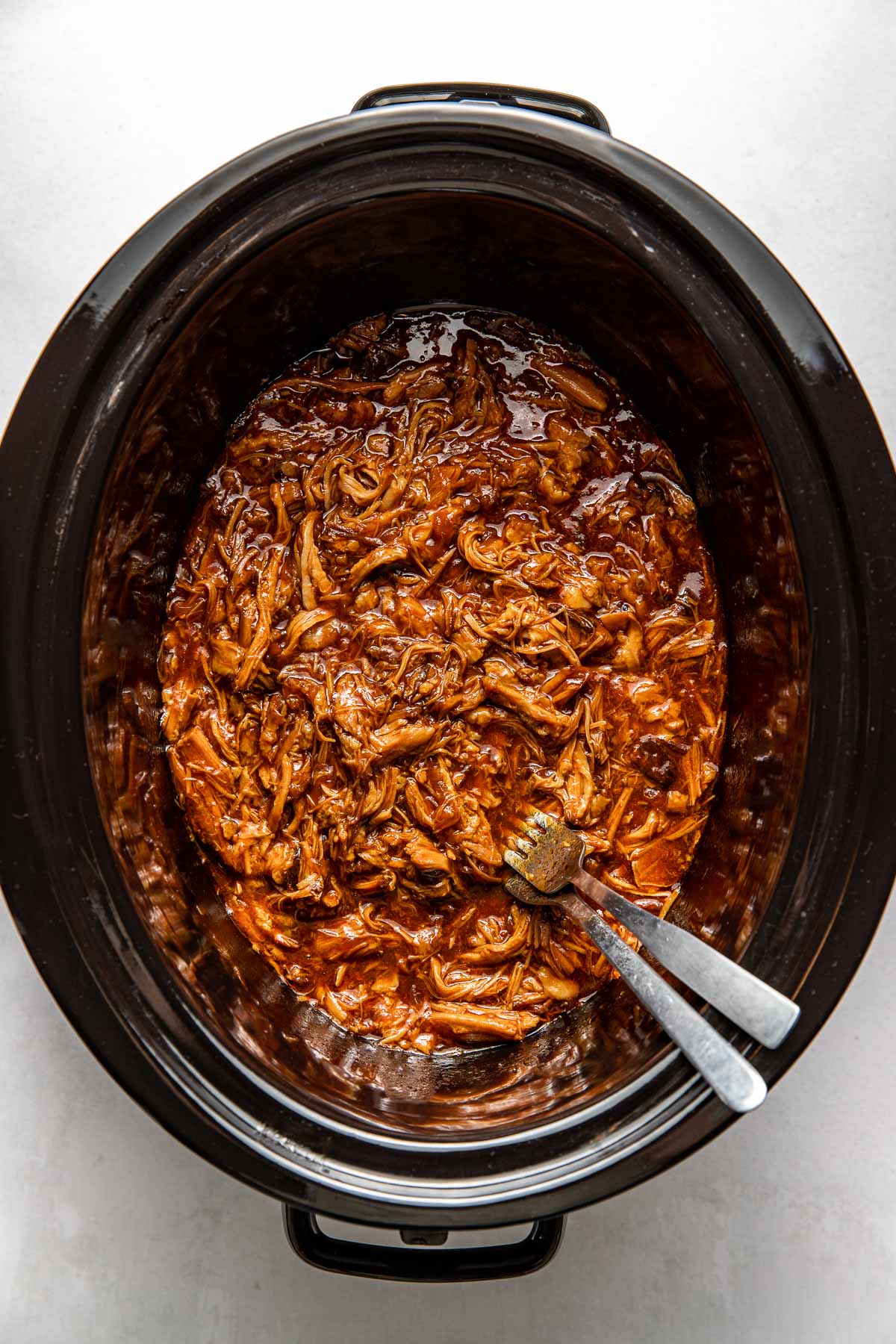 Overhead view of a slow cooker filled with BBQ pulled pork.