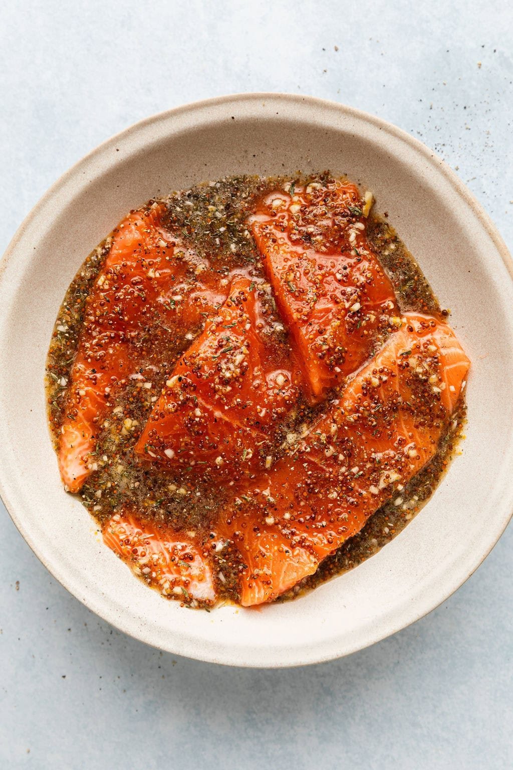 Overhead view of salmon in a bowl marinating 