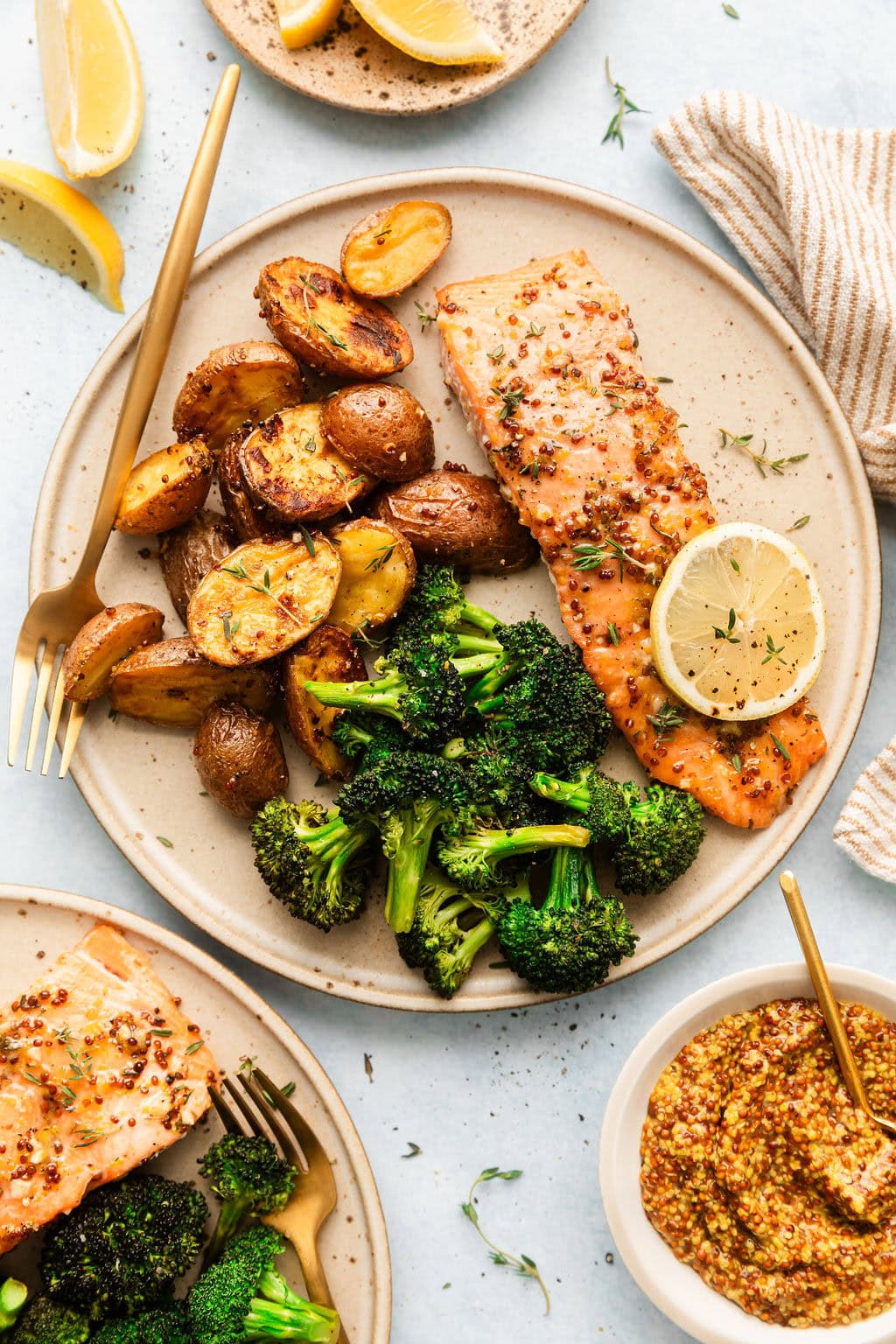Overhead view of a plate of Sheet Pan Honey Mustard Salmon with roasted potatoes and broccoli. 