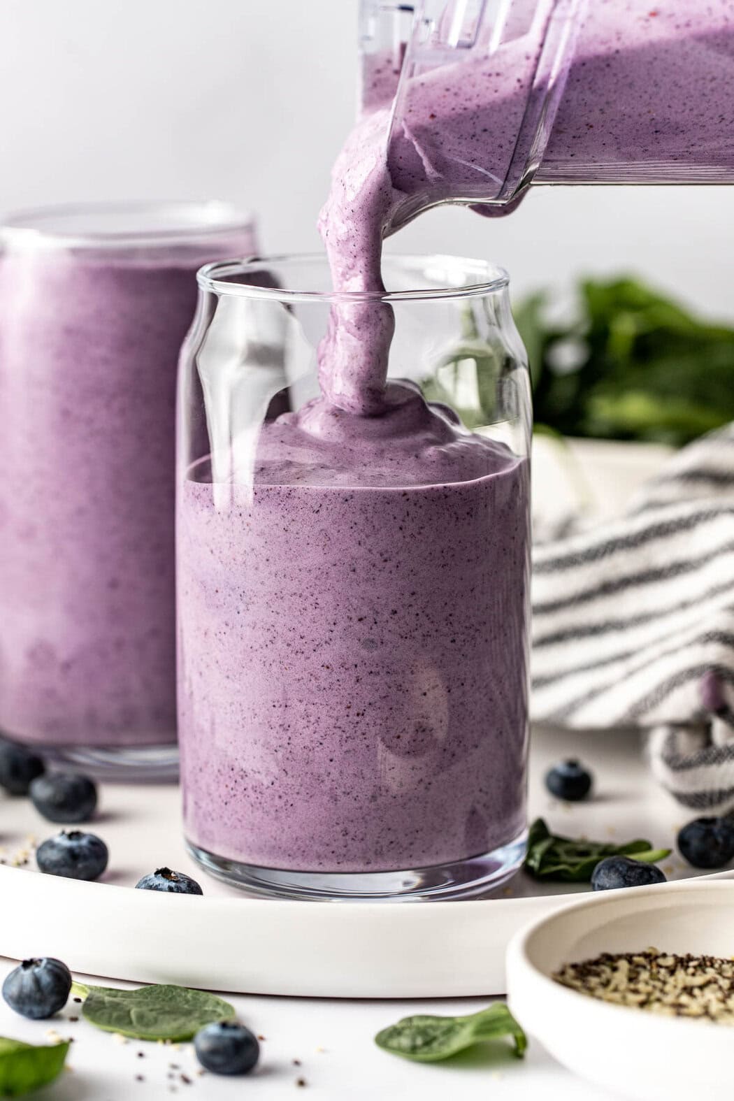 Close up view of a thick Post Workout Smoothie being poured into a glass from a blender pitcher