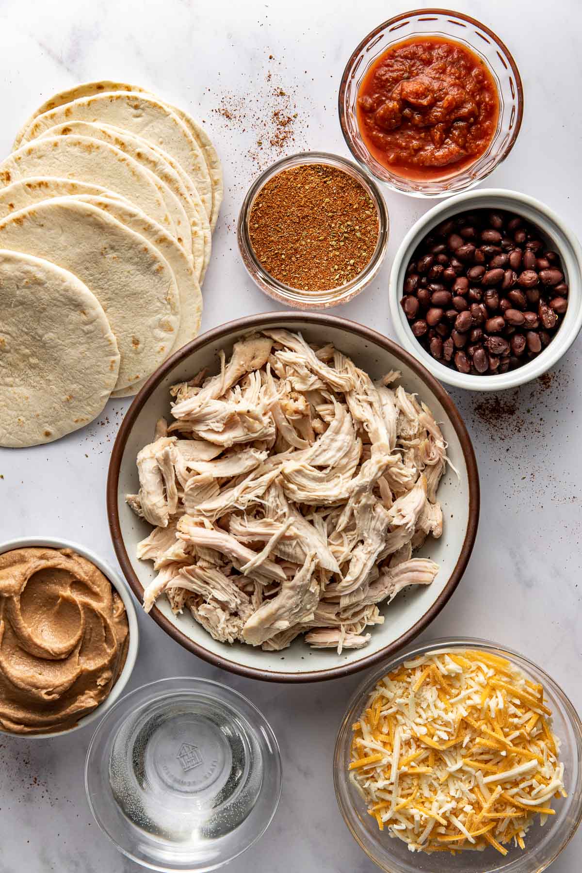 A variety of ingredients for Sheet Pan Chicken Tostadas in different sized bowls.