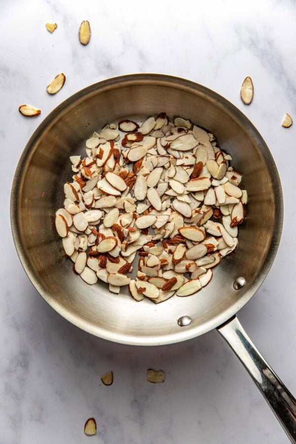 Overhead view of a skillet with toasted sliced almonds in it.