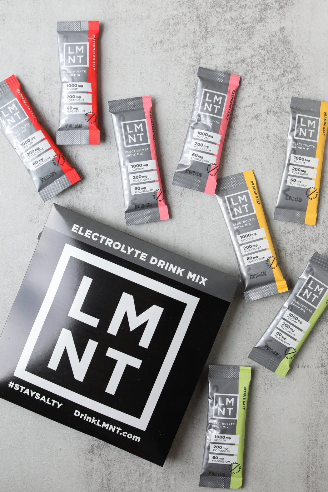 Overhead shot of an LMNT sample pack containing 2 sticks each of Raspberry, Watermelon, Orange, and  Citrus Salt flavors.