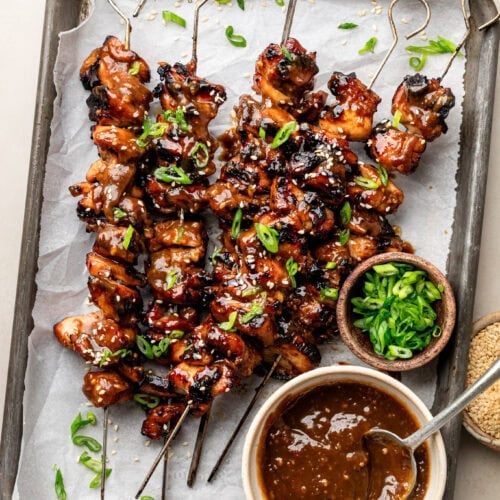 Overhead view sheet pan filled with grilled Korean BBQ chicken on skewers