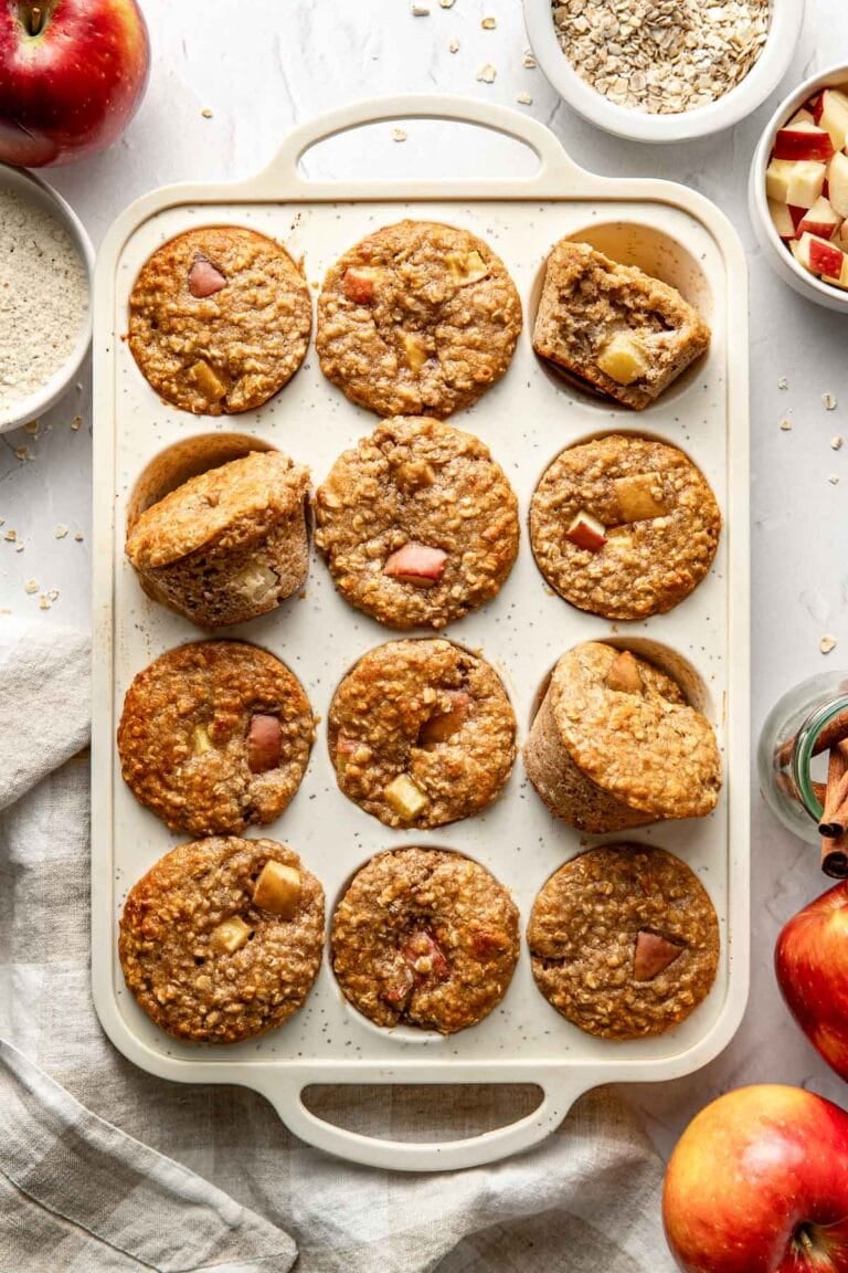 Overhead view of a muffin pan filled with apple cinnamon protein muffins. 
