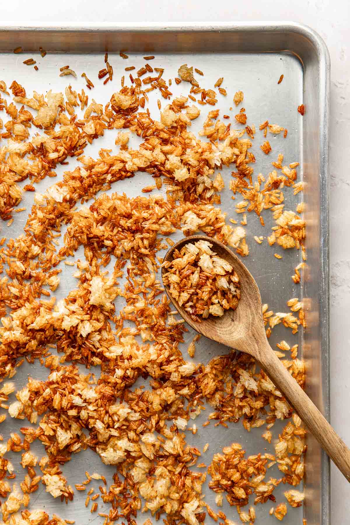 Overhead view of a sheet pan of crispy rice spread evenly across the pan. 