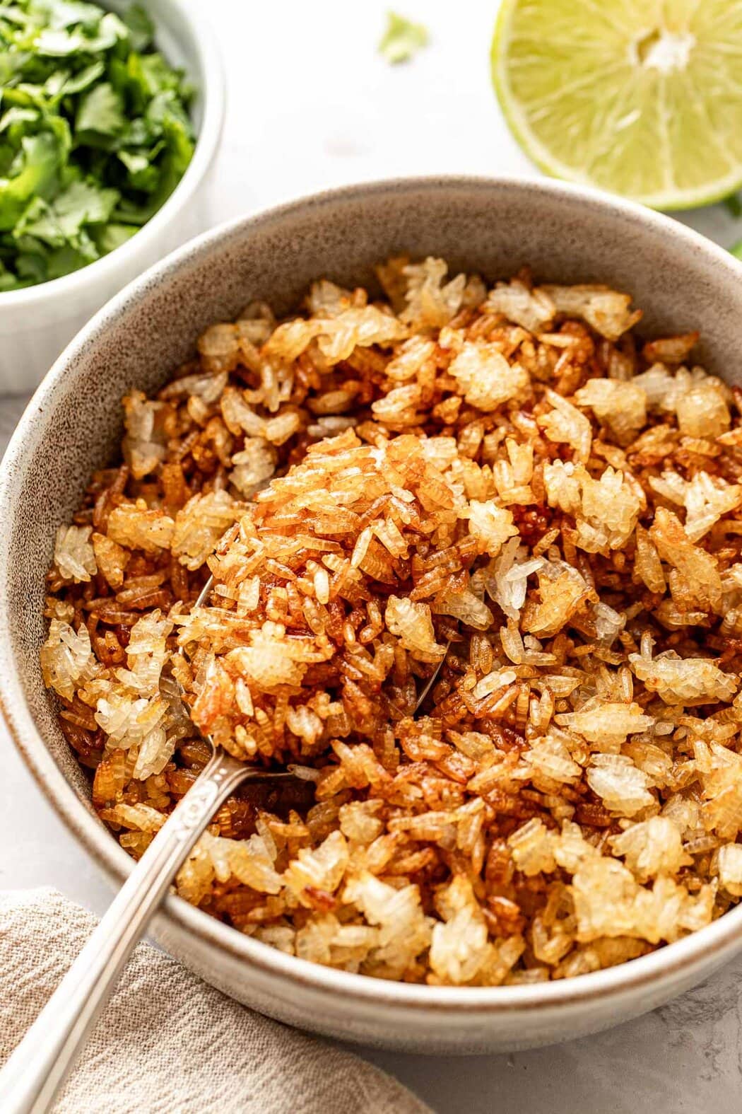 Close up view of a bowl filled with crispy rice and a spoon in the mixture. 