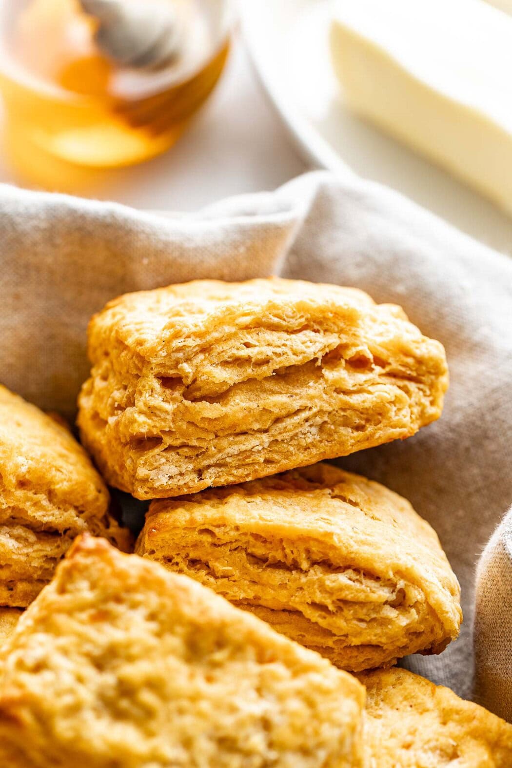 A close up view of the profile of a sweet potato biscuit showing its many flaky layers and light browned exterior.