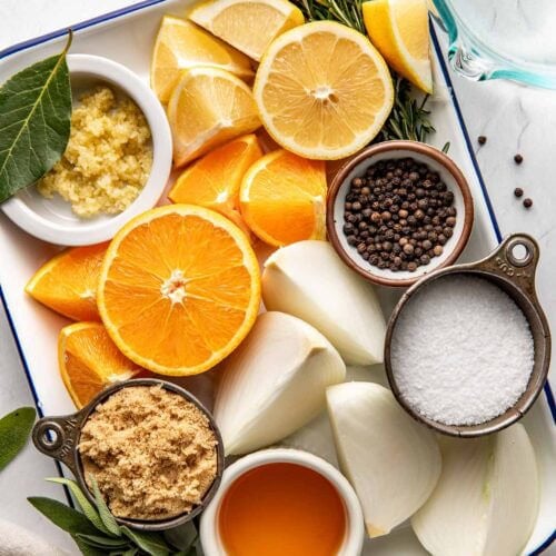 Overhead view of a platter filled with Turkey Brine ingredients including sliced lemons and oranges.