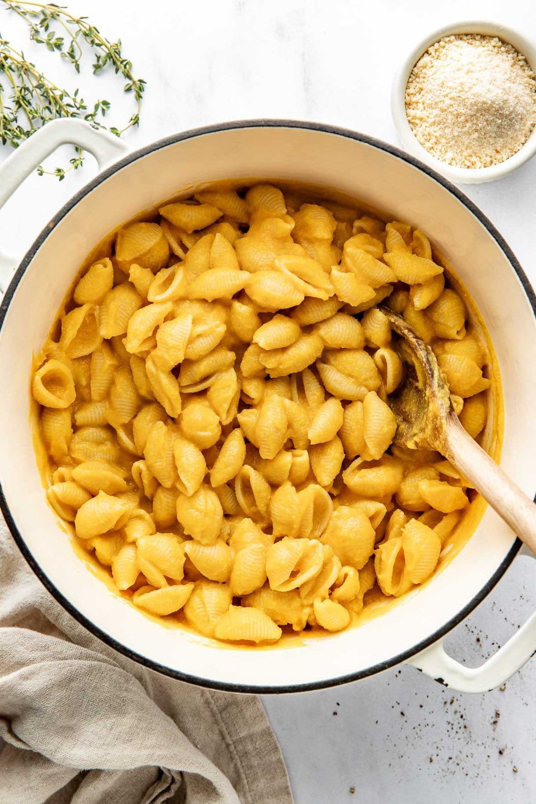 Overhead view of a pot of Butternut Squash Mac and Cheese being stirred with a wooden spoon.