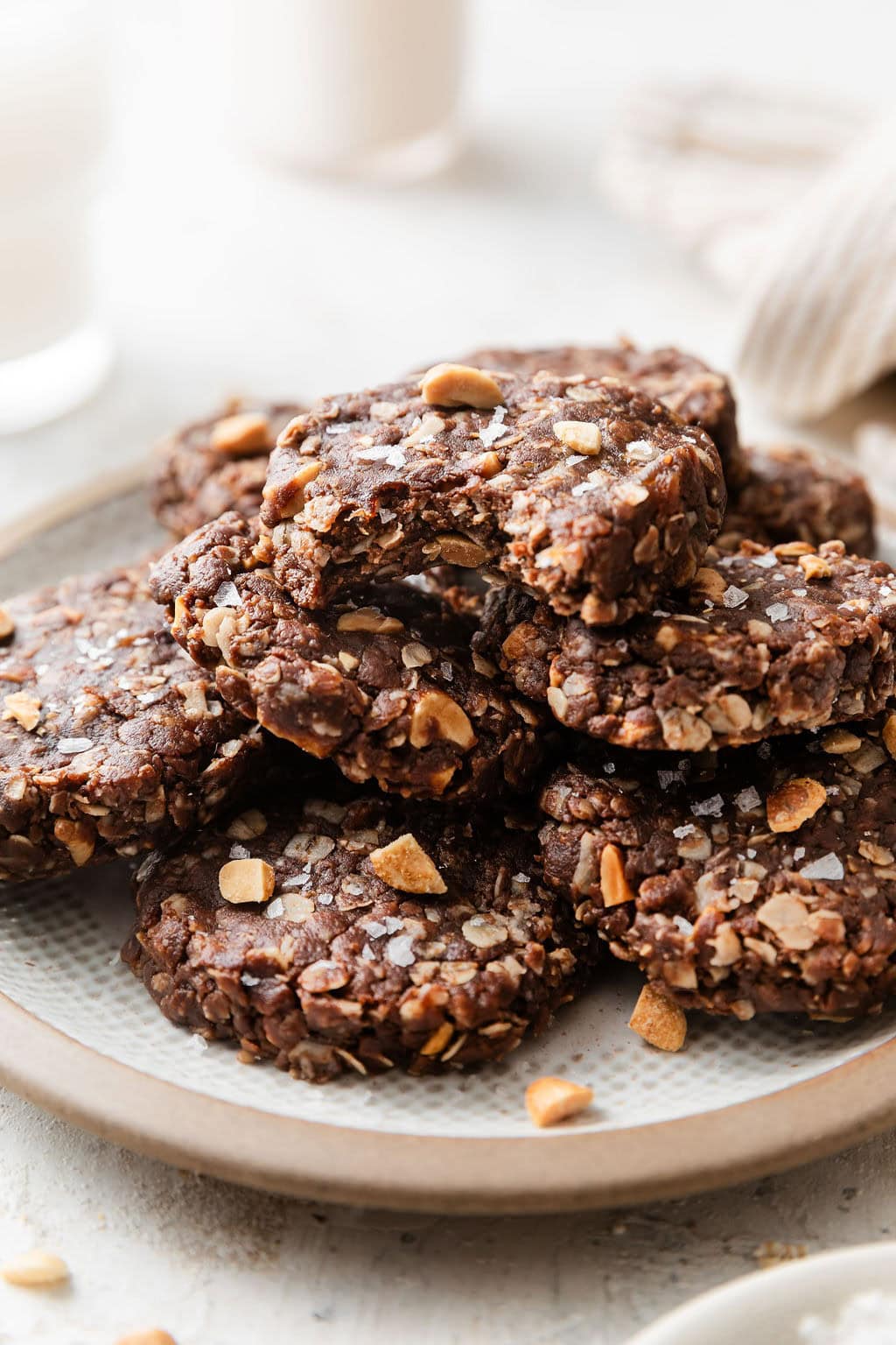 Close up view of a stacked batch of No Bake Cookies topped with flakey sea salt. 