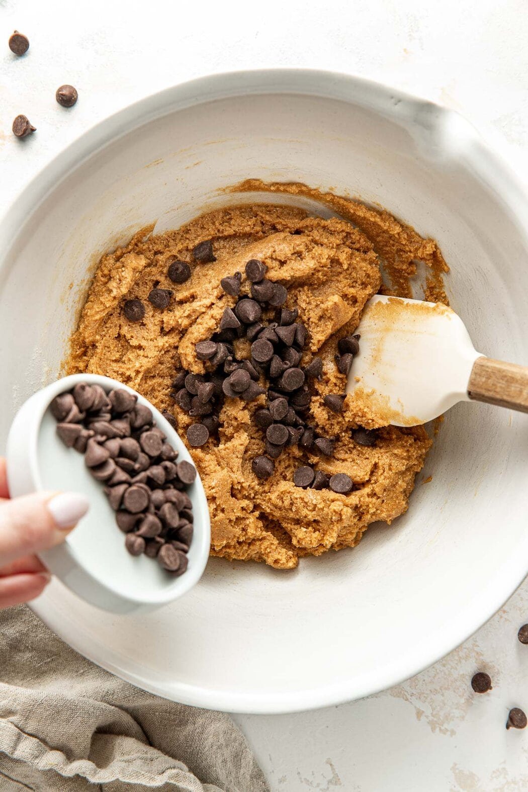 Overhead view of a bowl filled with Protein Cookie dough sprinkled with chocolate chips.