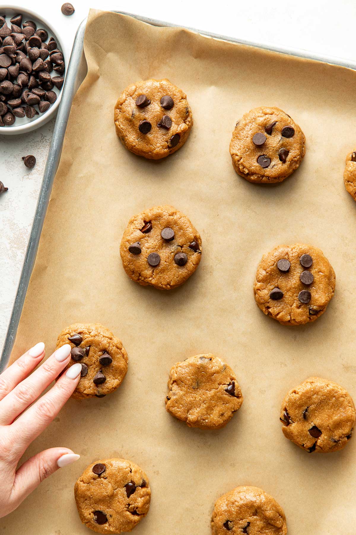 Overhead view a sheet pan lined with parchment paper topped with Protein Cookie dough ready for baking.