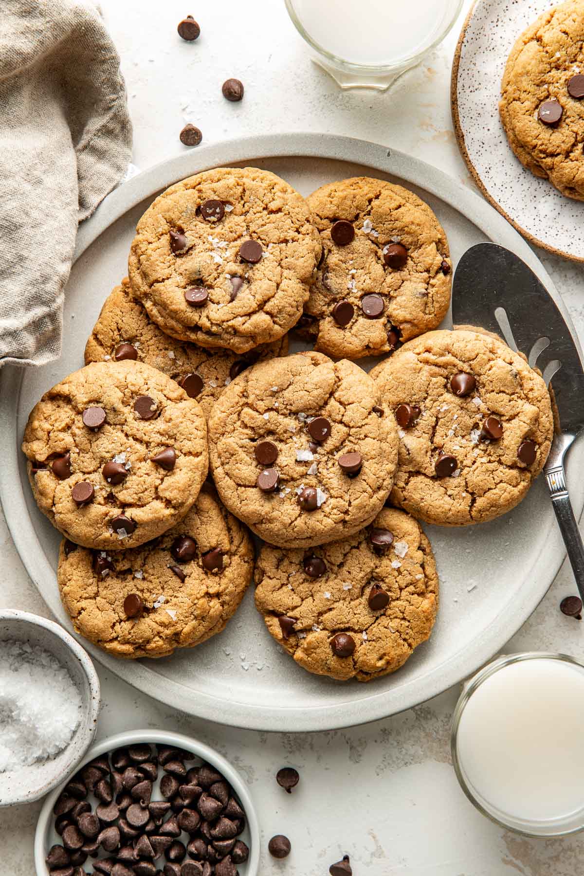 Overhead view of plate of freshly baked Protein Cookies topped with chocolate chips and sprinkled with flakey sea salt.