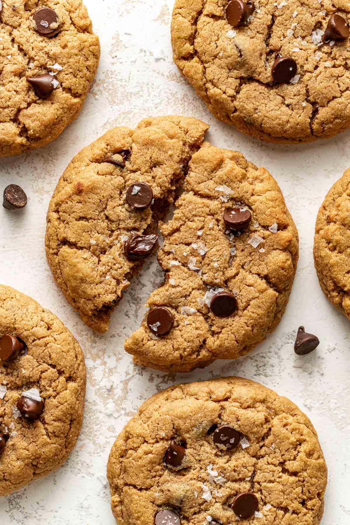 Overhead view of freshly baked Protein Cookies topped with melty chocolate chips and sprinkled with flakey sea salt. 