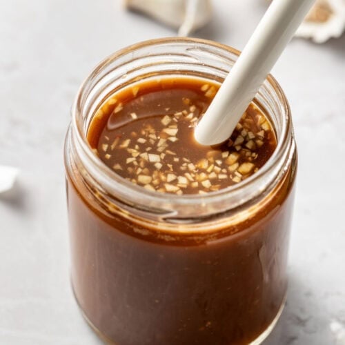Overhead view of a glass jar of Stir Fry Sauce with a whisk in the jar.