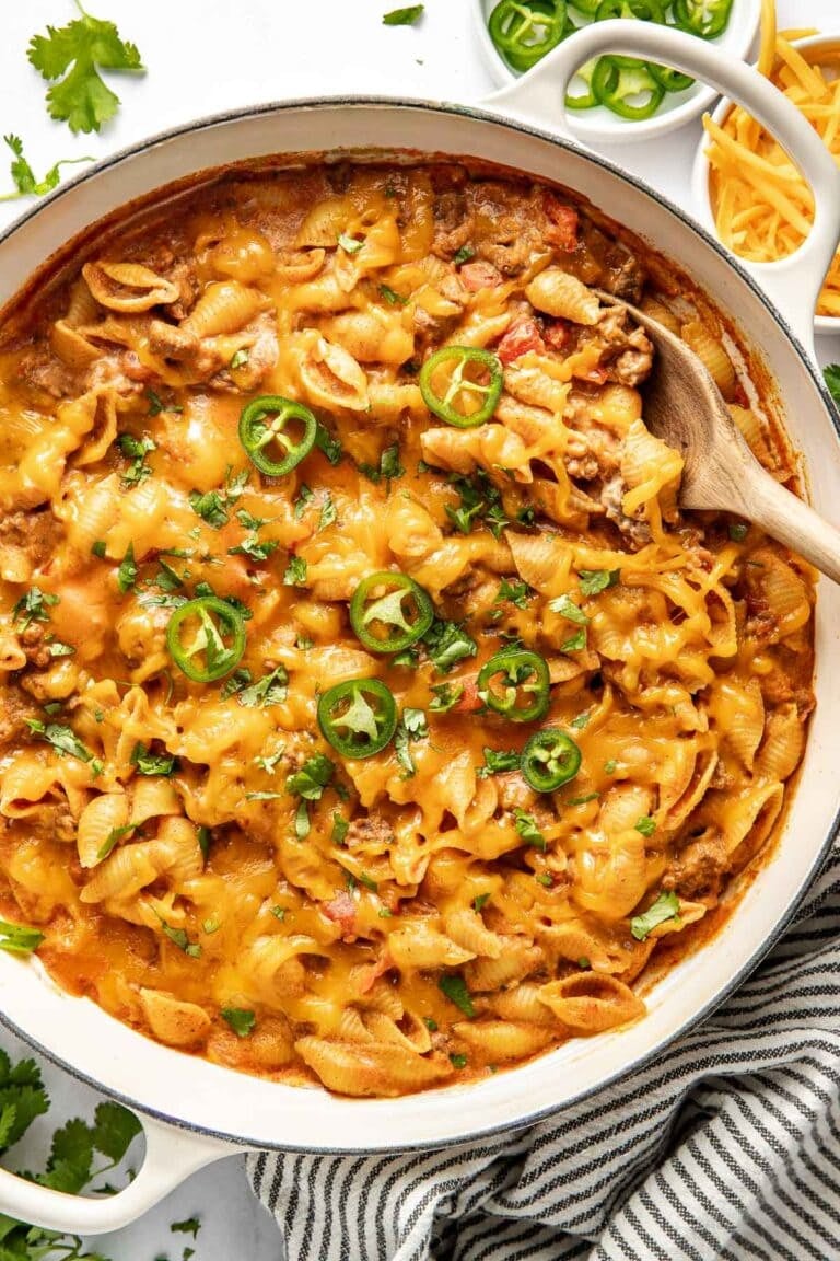 Overhead view of a skillet filled with taco pasta topped with sliced jalapenos.