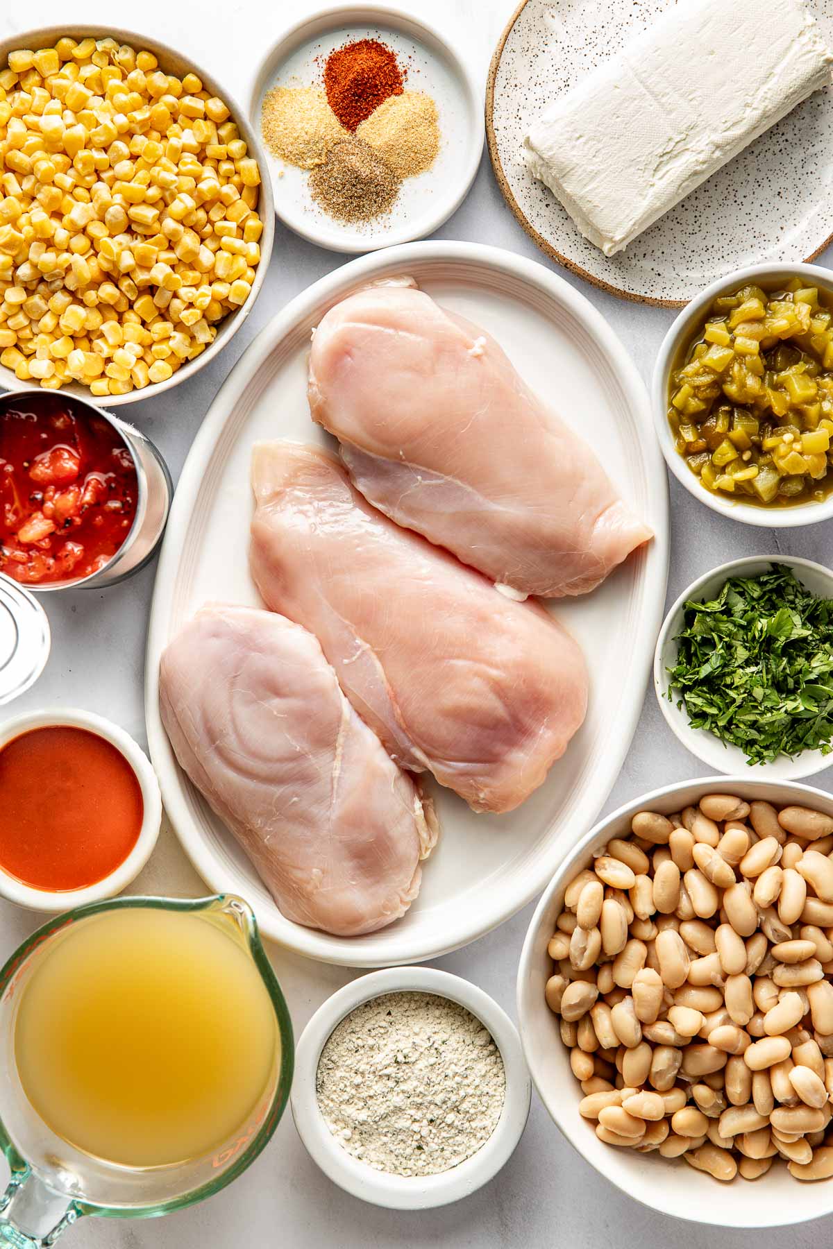 Overhead view of a variety of ingredients for Buffalo Chicken Chili in different sized bowls.