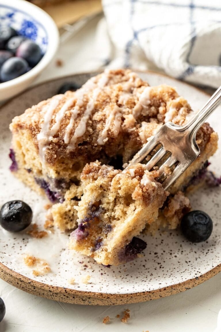 Overhead view of a piece of Blueberry Coffee Cake with a fork going into the side.