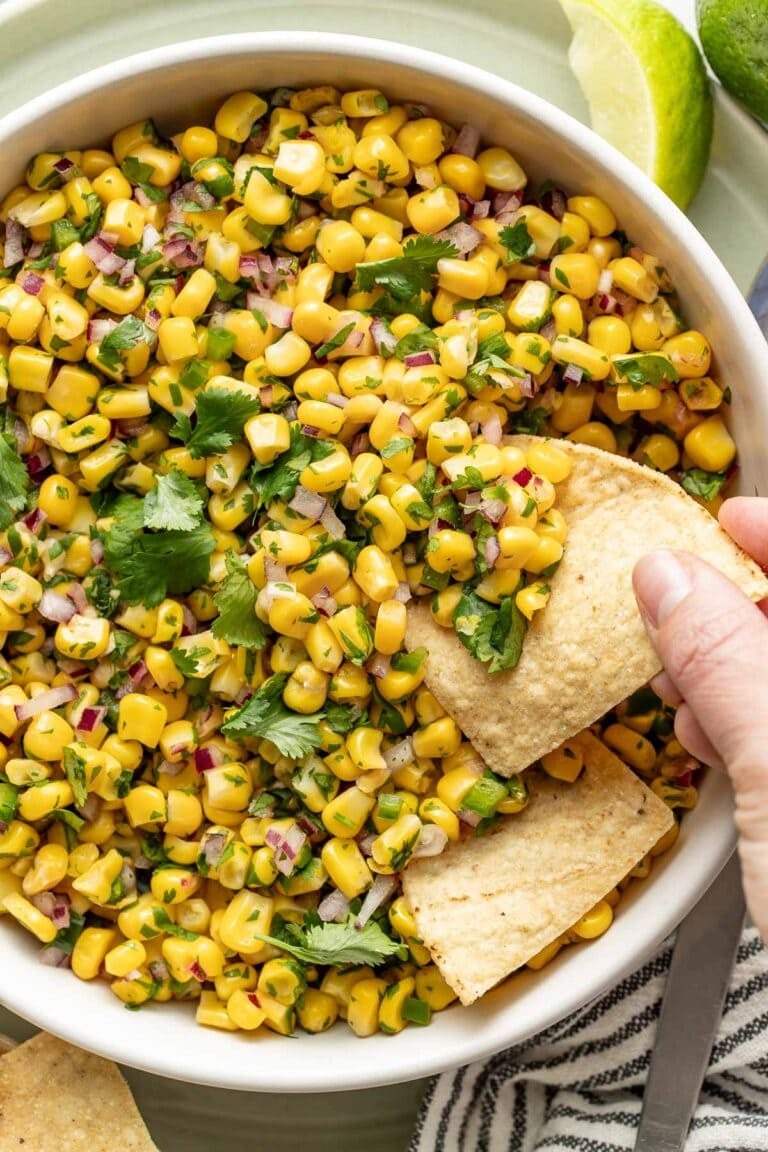 Overhead view of a bowl of copycat chipotle corn salsa topped with fresh cilantro.