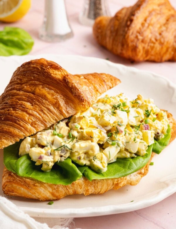 Side view of egg salad in a croissant plated