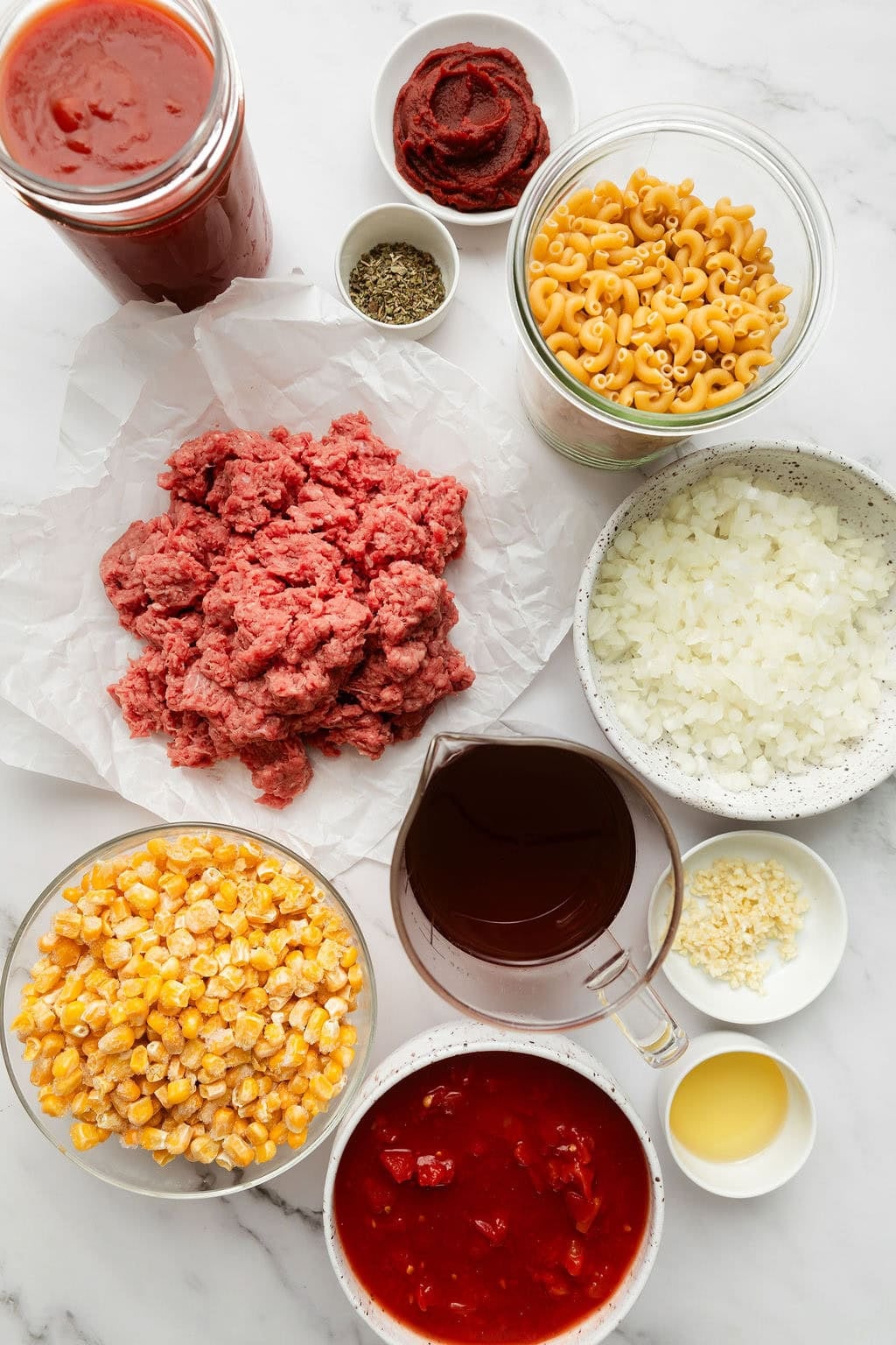 Overhead view of a variety of ingredients for goulash in different sized bowls.