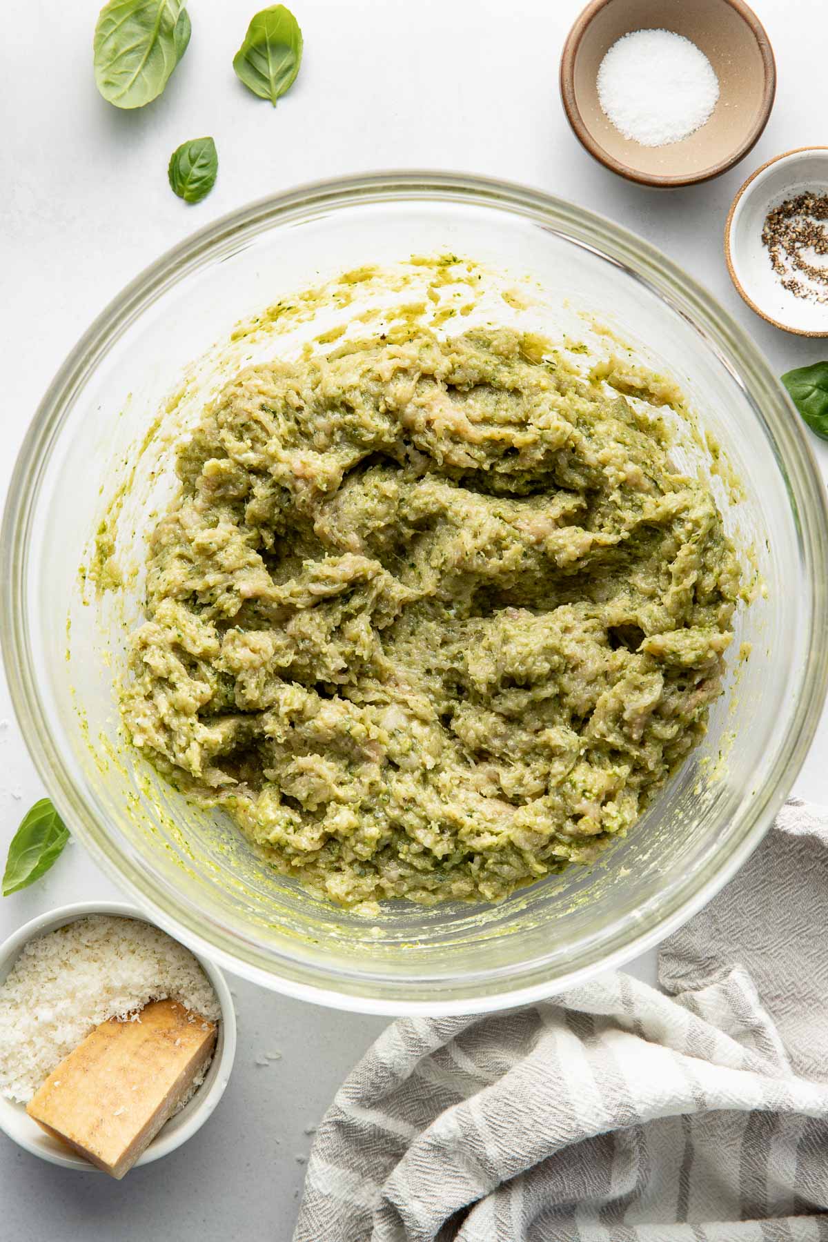 Overhead view of a glass bowl of Pesto Meatball meat mixture. 
