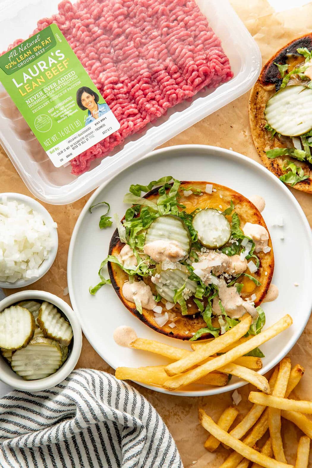 Overhead view of a Smash Burger Taco on a plate next to a package of ground beef. 