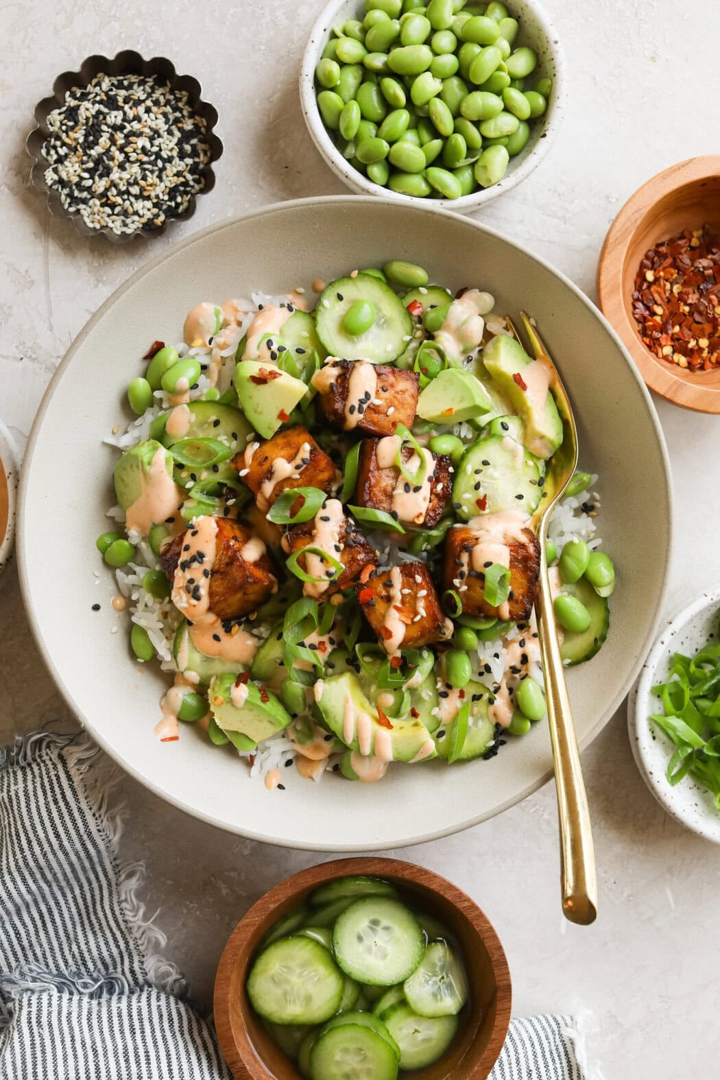 Overhead view of a bowl of salmon bites topped with edamame and green onions.