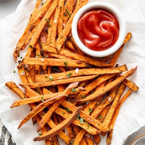 Overhead view of Air Fryer Sweet Potato Fries arranged around a small bowl of ketchup.