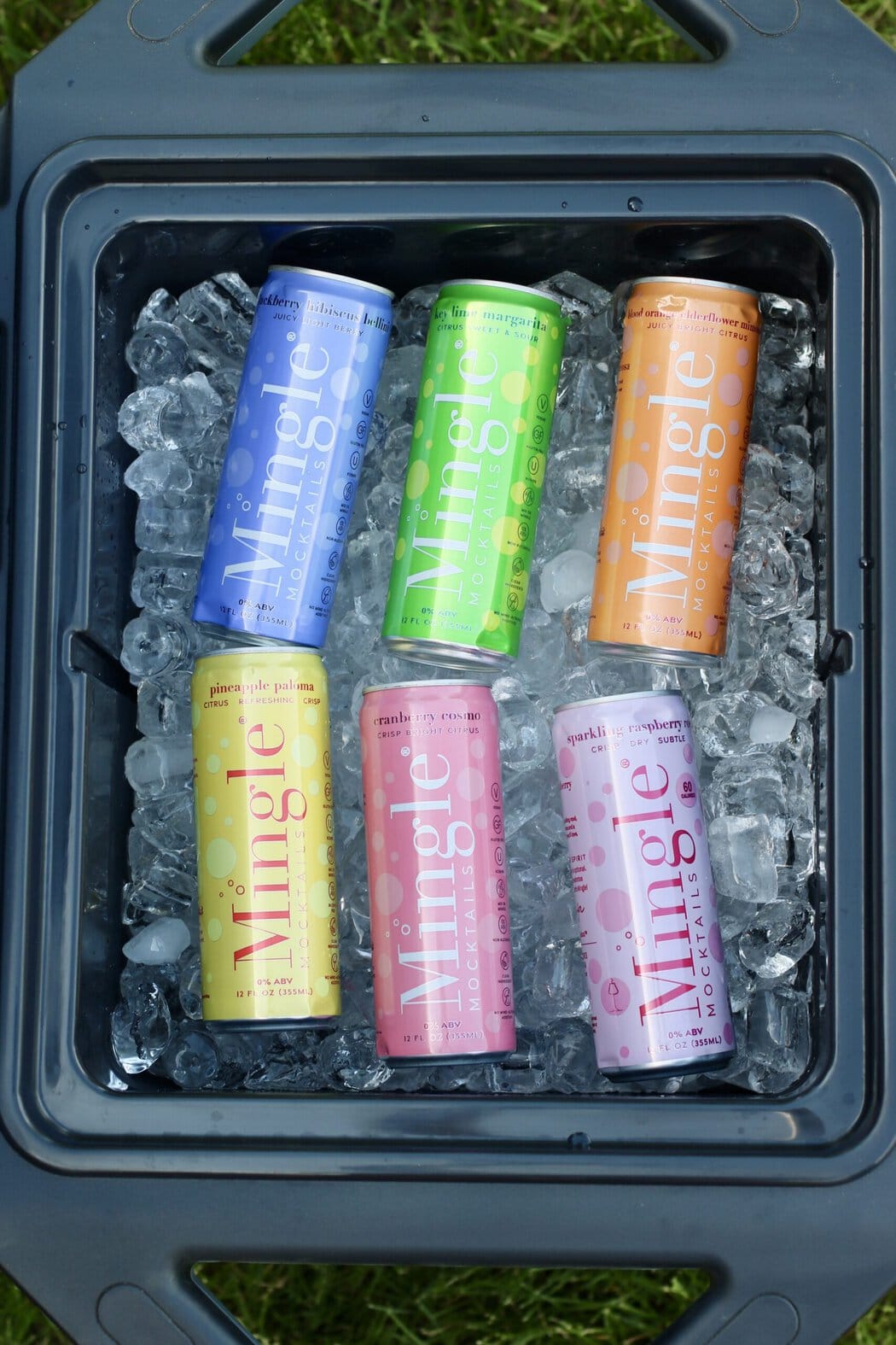 Overhead view of an open cooler filled with ice and mingle brand canned mocktails.