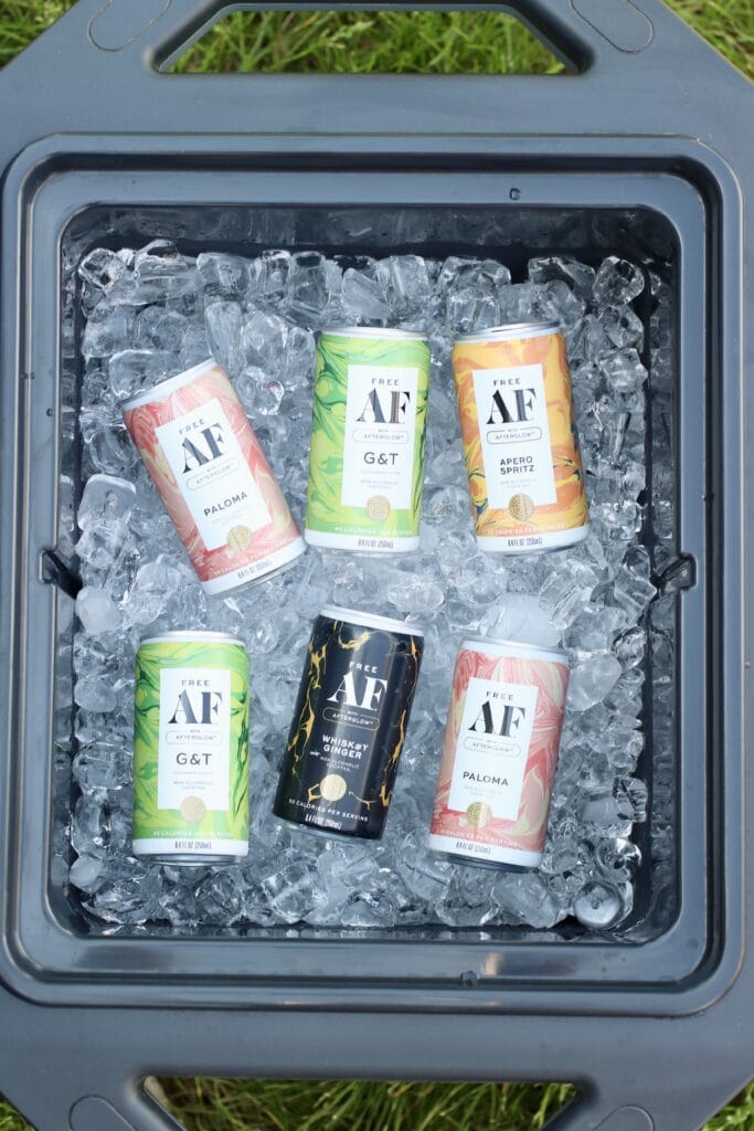 Overhead view of a cooler full of ice and canned mocktails with colorful can varieties.