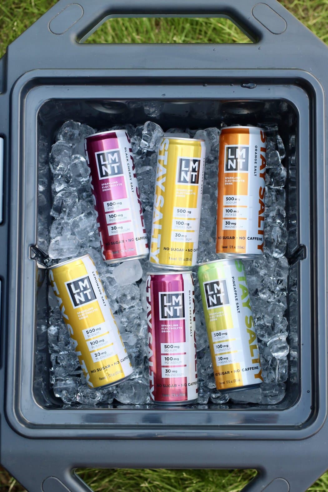 Overhead view of an open cooler of ice with canned LMNT sparkling drinks on top.