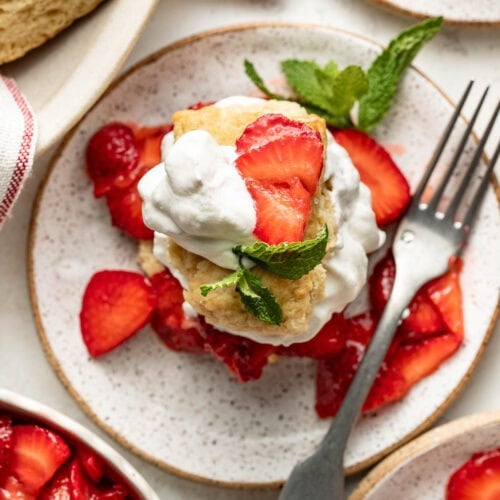 Overhead view of a piece of strawberry shortcake topped with whipped cream.