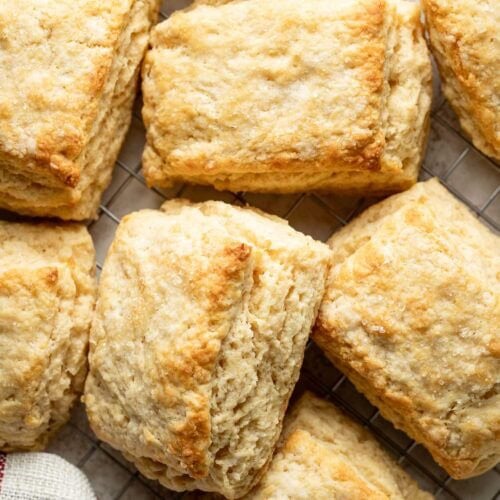 Overhead view of Sweet Cream Biscuits arranged on parchment paper showing the flakey layers.