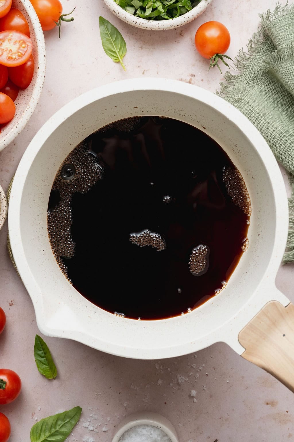 Balsamic glaze being brought to a boil in a small saucepan. 