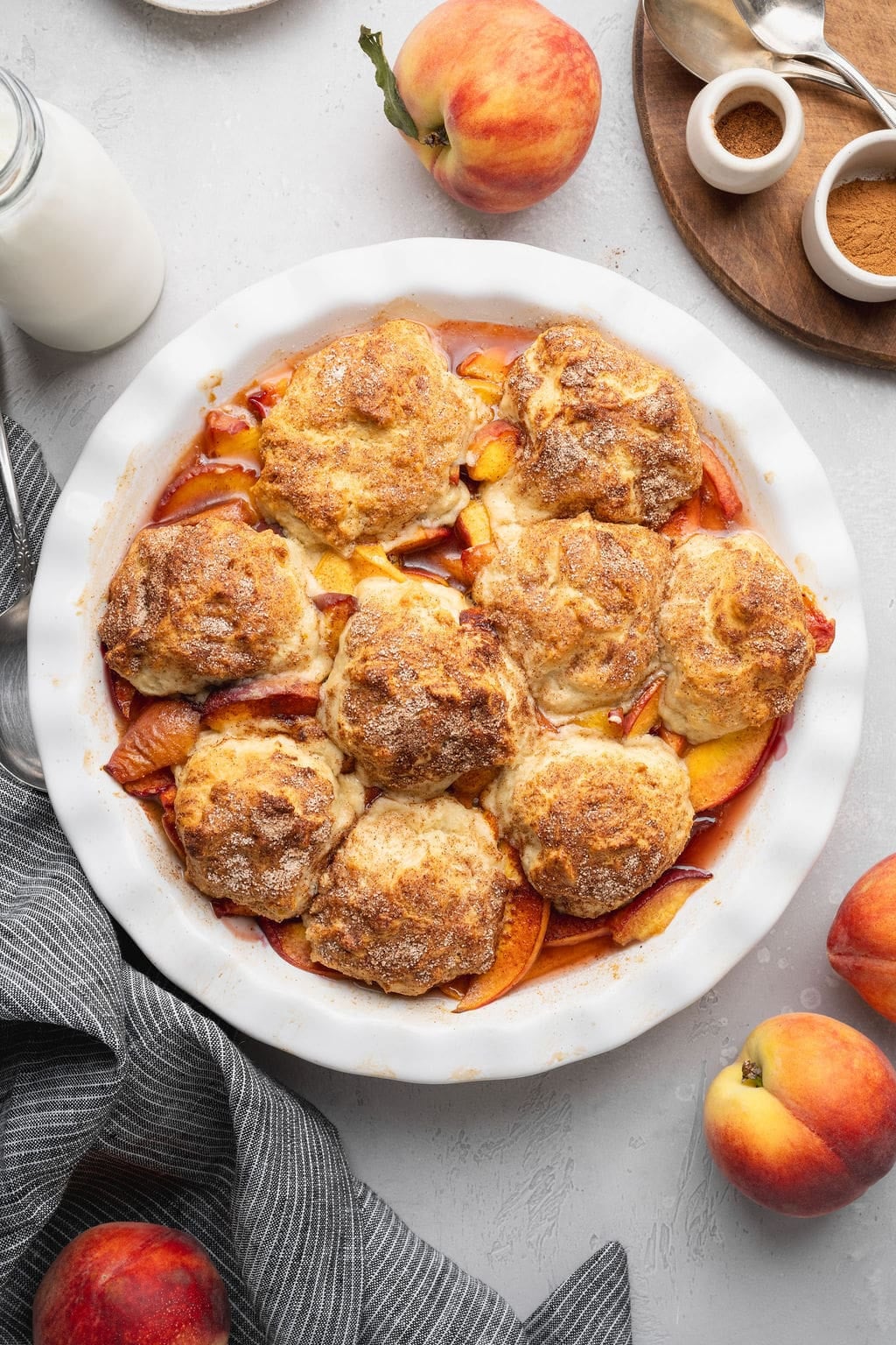 A finished peach cobbler in a round baking dish.